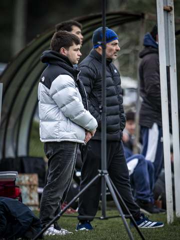 Hincha con gorro The North Face junto a su hijo en la cancha