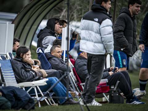Hinchas tomando mate en reposeras al costado de la cancha