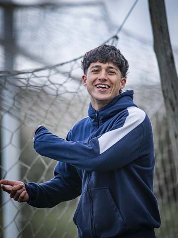 Jugador del plantel sonriendo junto al arco